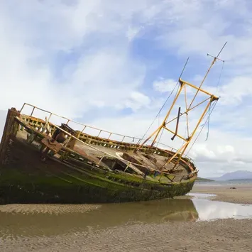 A photo of a sailing ship leaning on a beach