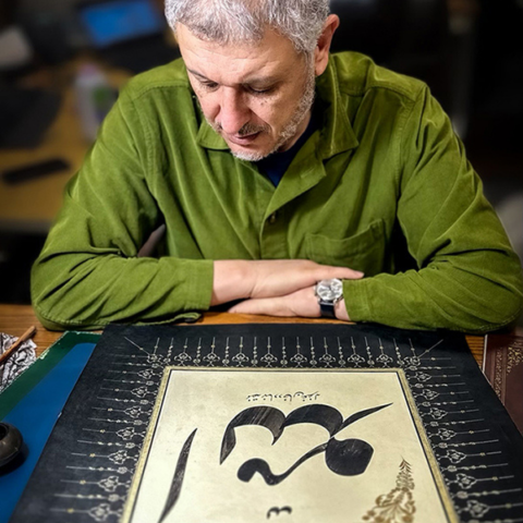 a man looking at Arabic calligraphy