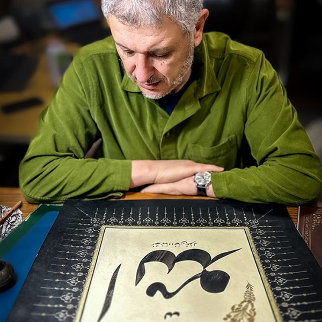 a man looking at Arabic calligraphy