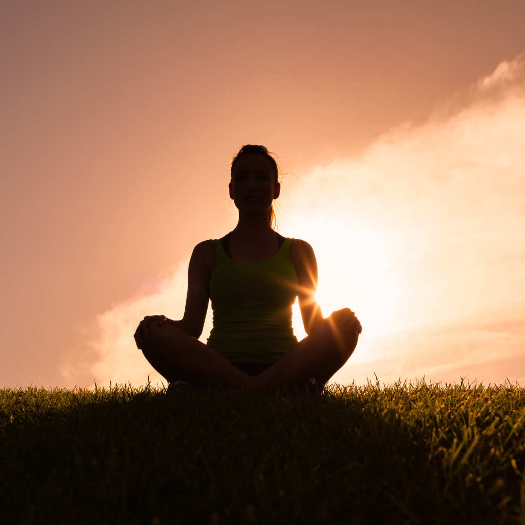 Silhouette of a person meditation as the sun is setting. 